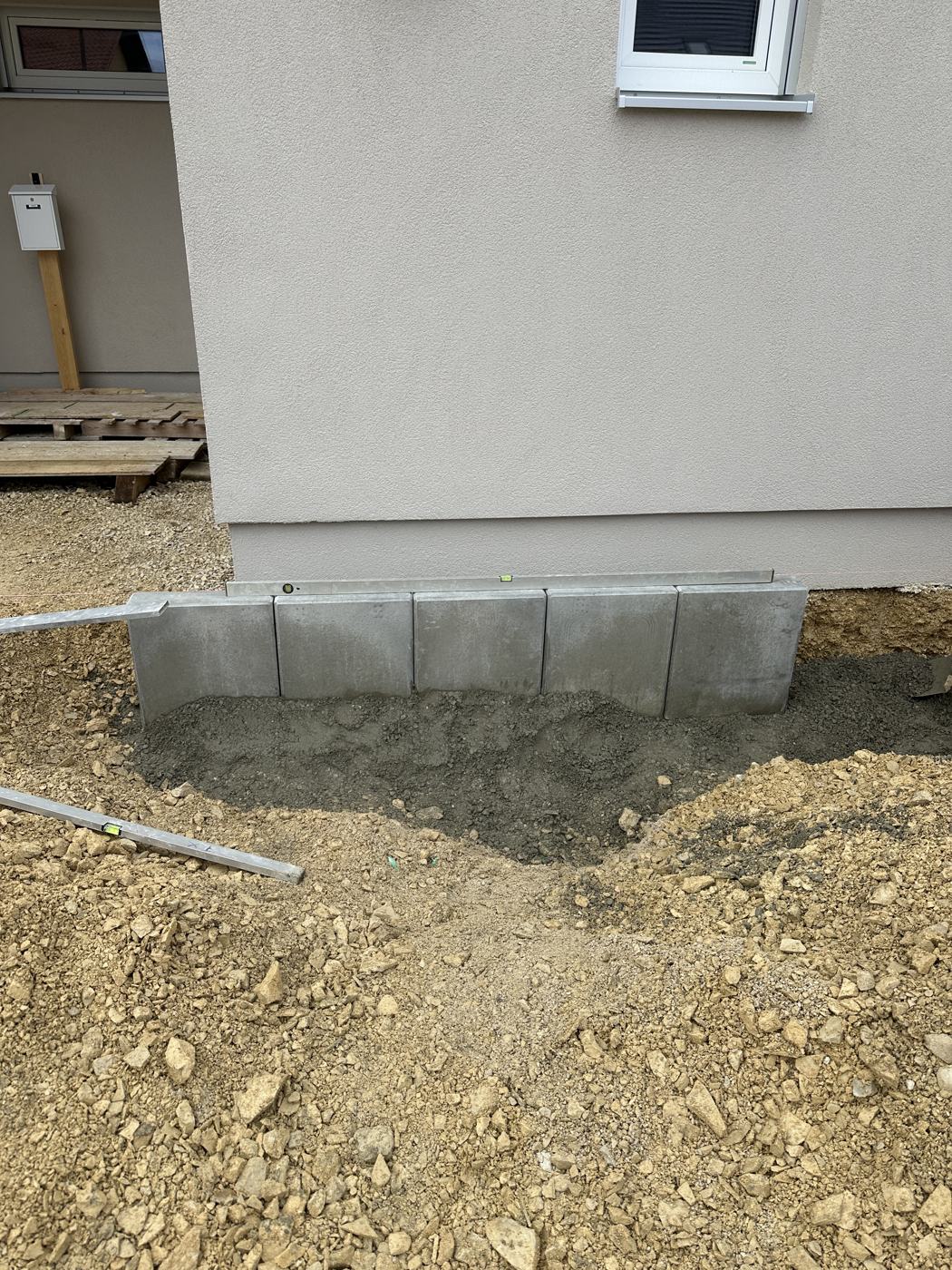 Gesetzte Betonelemente als Randeinfassung am Gebäude