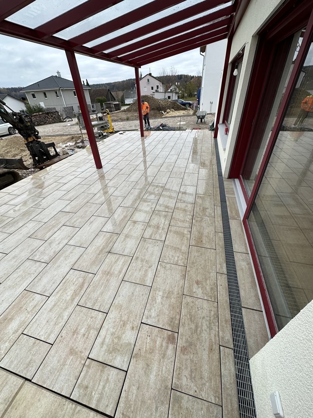 Fertige Terrasse mit großformatigem Plattenbelag unter Pergola