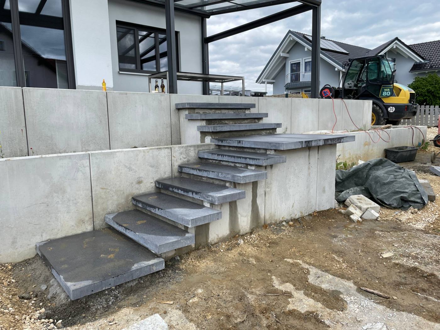 Außenanlagen – freitragende Blockstufentreppe mit Betonstützmauer